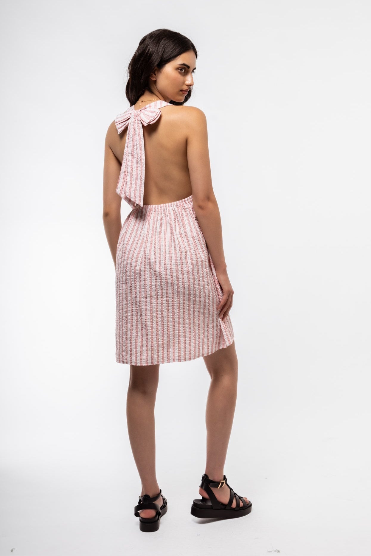 Back view of halterneck dress with exposed shoulders and subtle zipper closure