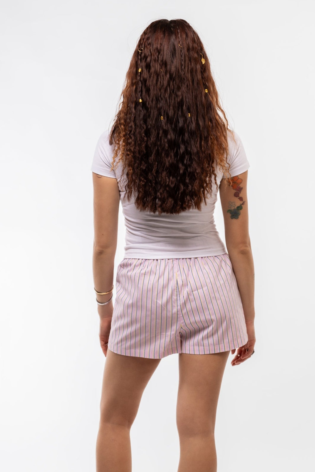 Back view of pink striped women’s shorts with elastic back waistband and tie front detail.