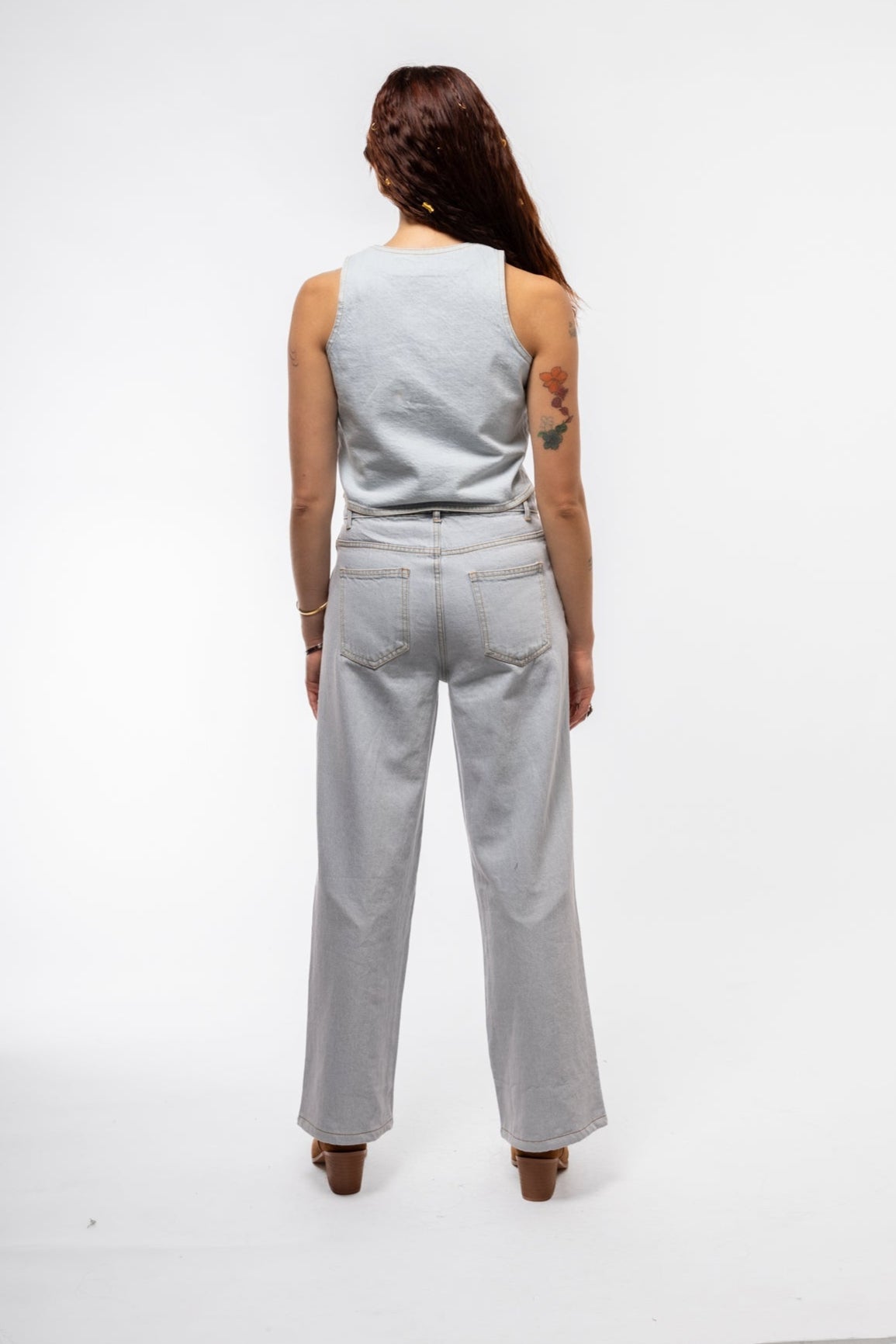 Back view of stud denim waistcoat with minimal seams and subtle stud accents