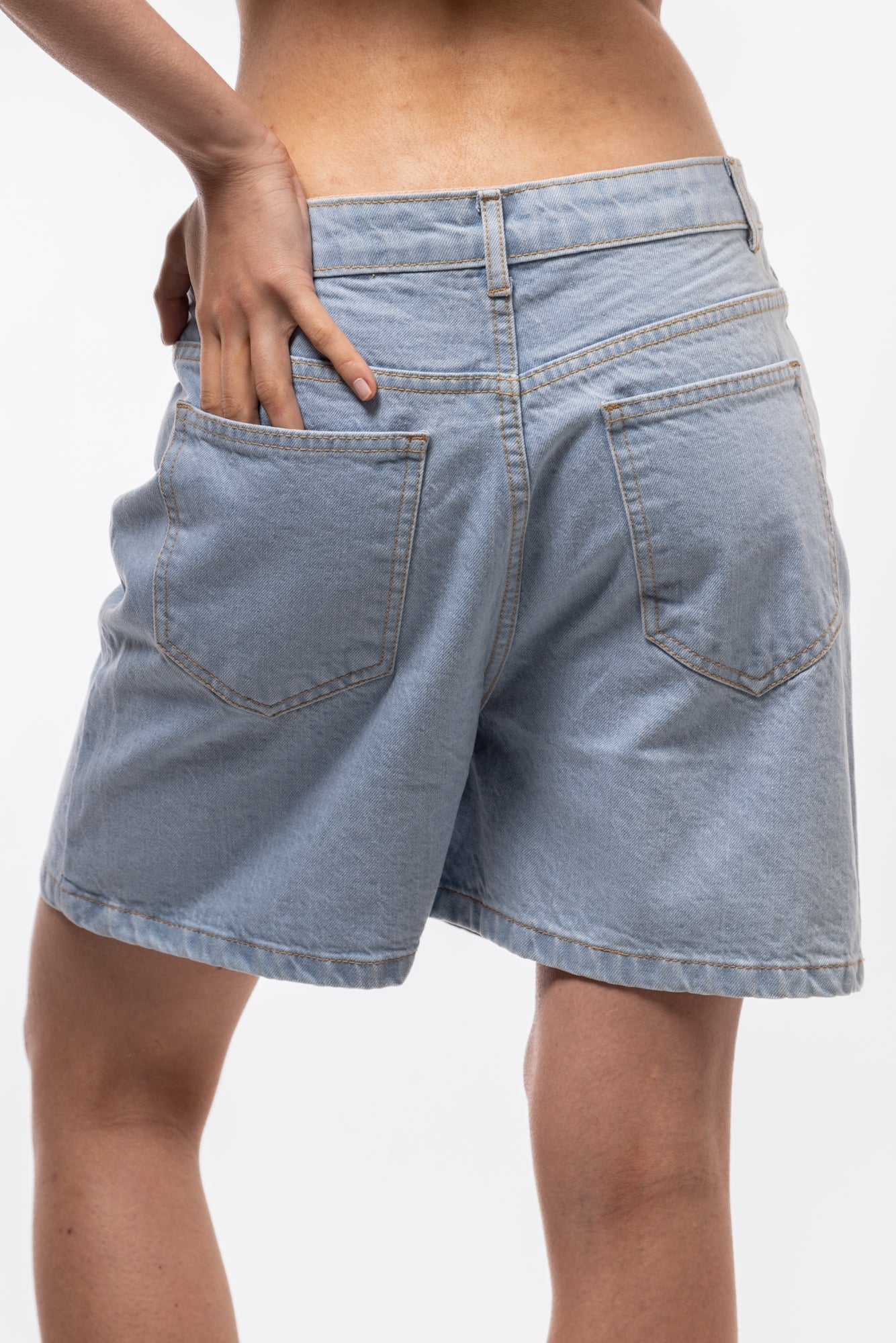 Comfortable fit of tA Relaxed Denim Shorts captured from the back with subtle fading