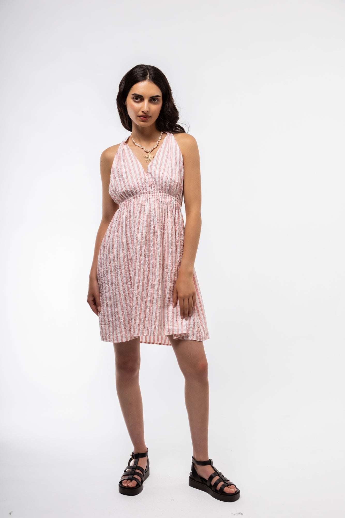 Front view of halterneck dress featuring elegant bow detail on the side and a fitted silhouette