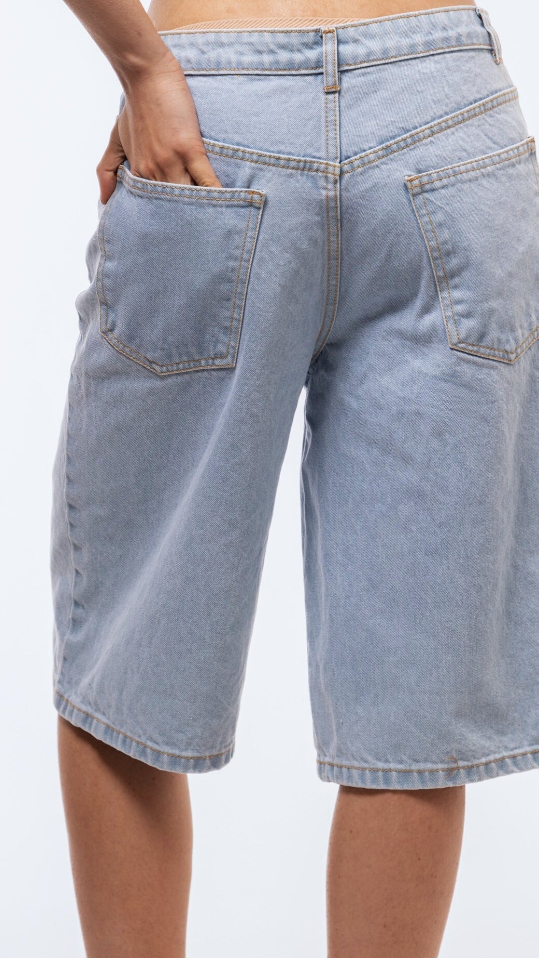 Longline denim jorts back image showcasing classic pocket stitching and extended leg length.