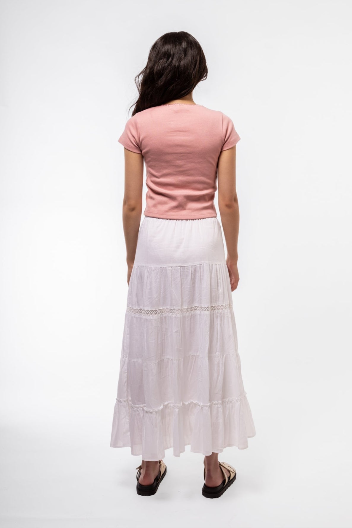 Model in pink lace tee, back view highlighting flattering silhouette