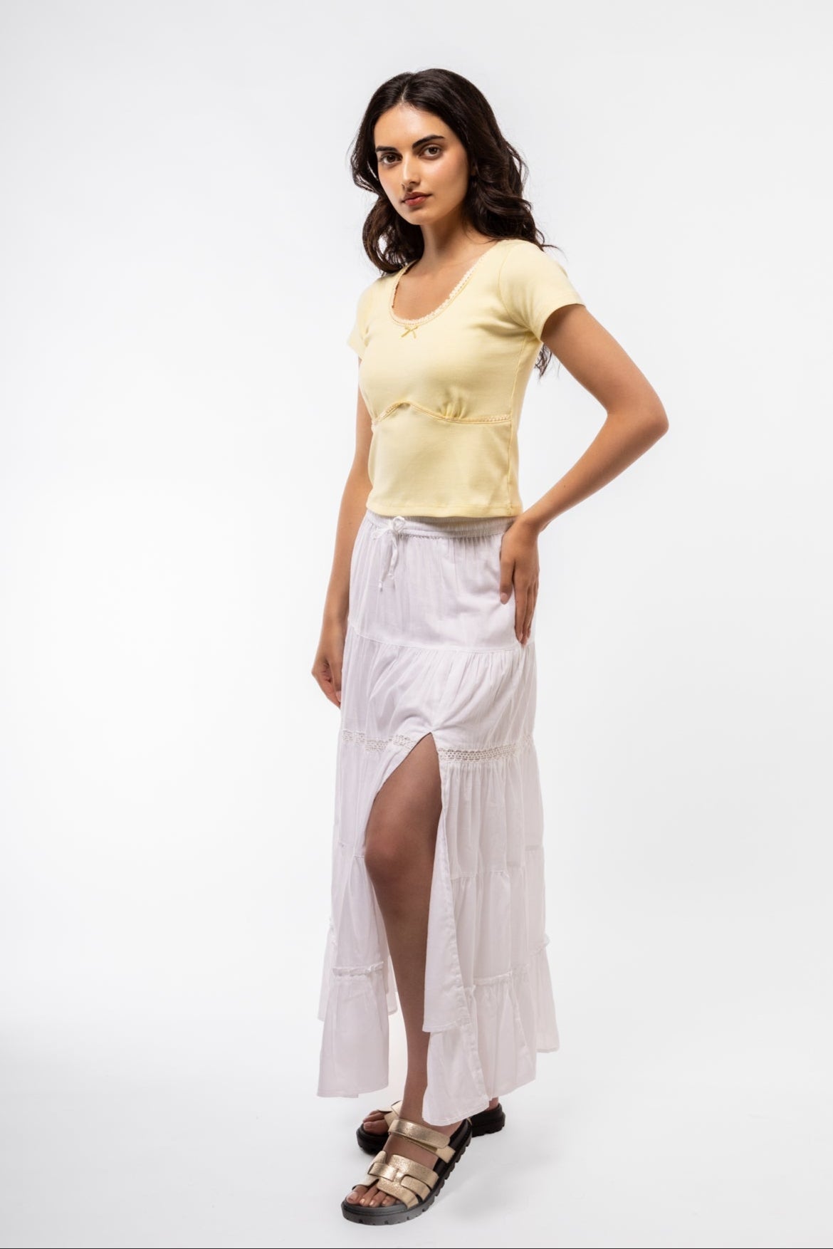 Model wearing lemon scoop neck top with lace accents, adding a cheerful vibe