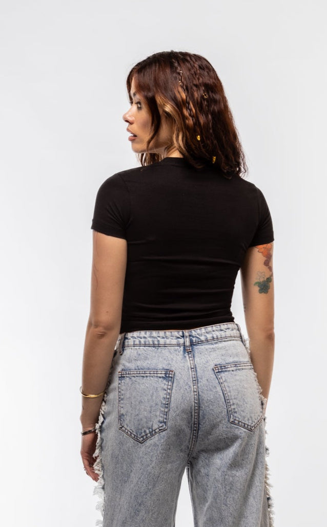 Person wearing high-waisted gray jeans and a black top on a white background