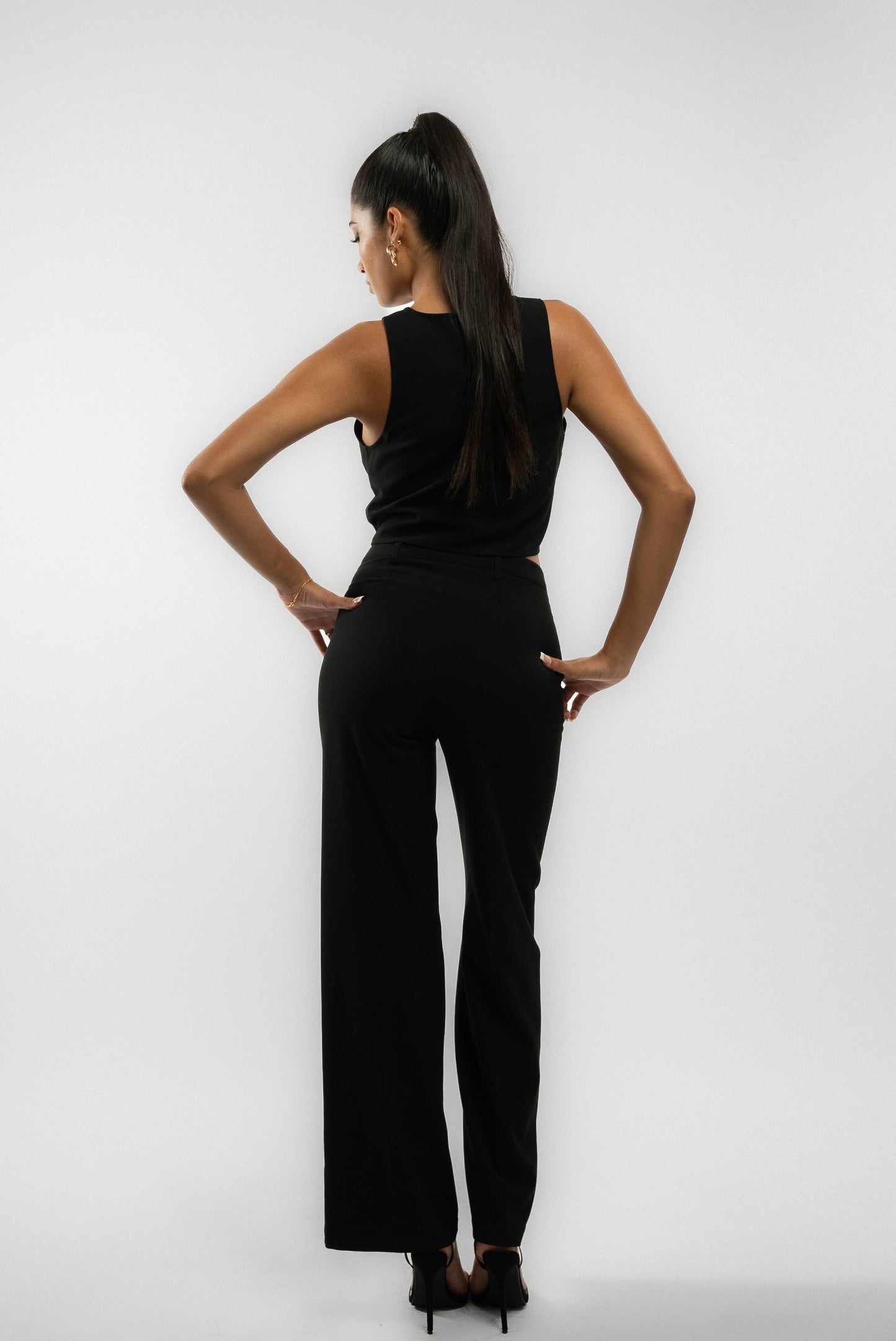 a woman in a black tailored wide leg trouser posing
