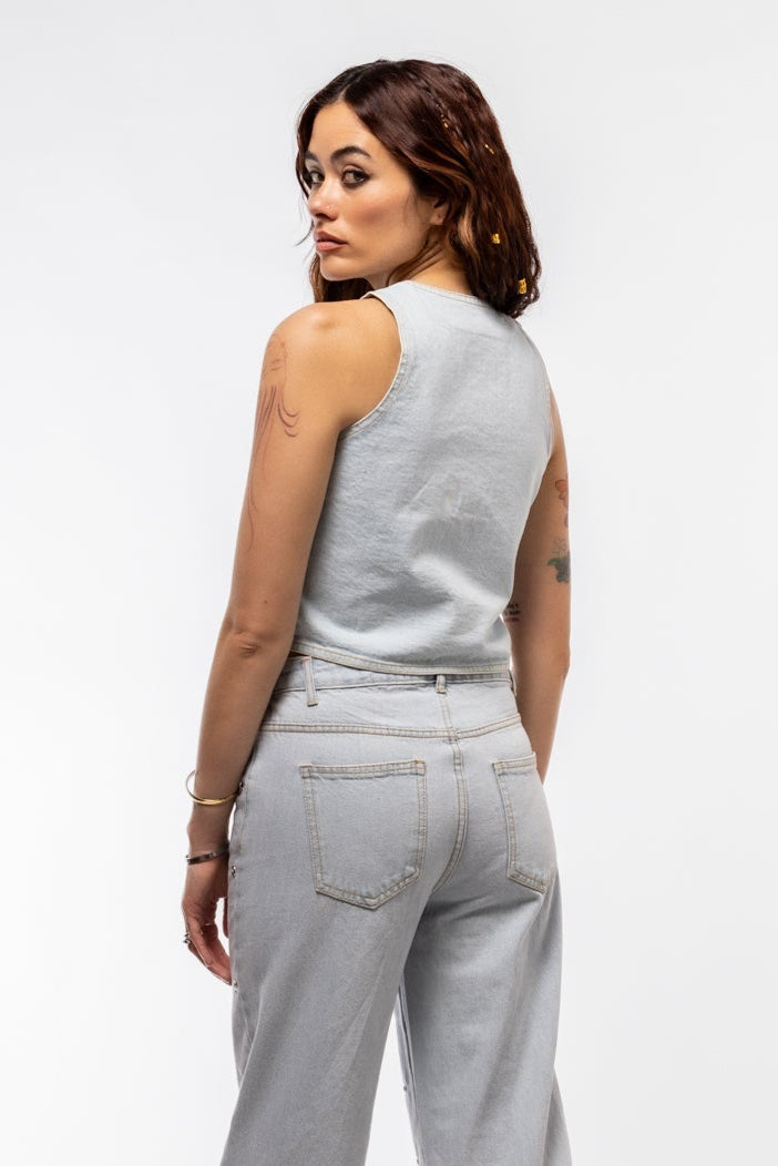Side view of denim vest with bold stud embellishments and clean seam lines