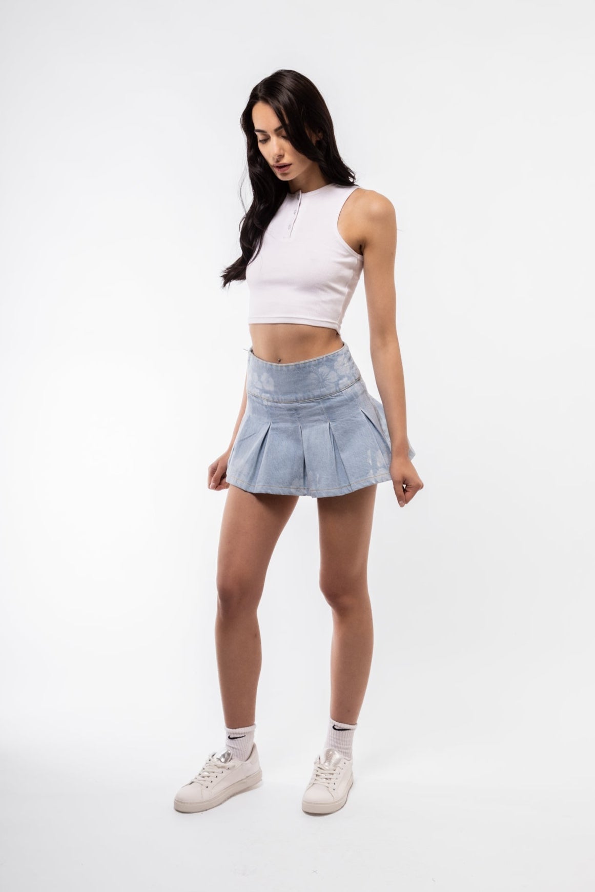 Trendy low rise skirt with denim print and pleated front, perfect for casual streetwear looks.