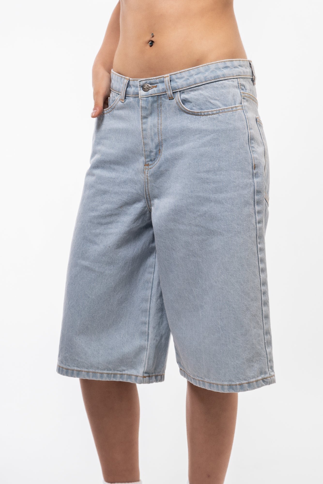 Vintage-style longline denim jorts side profile with loose silhouette and casual drop.