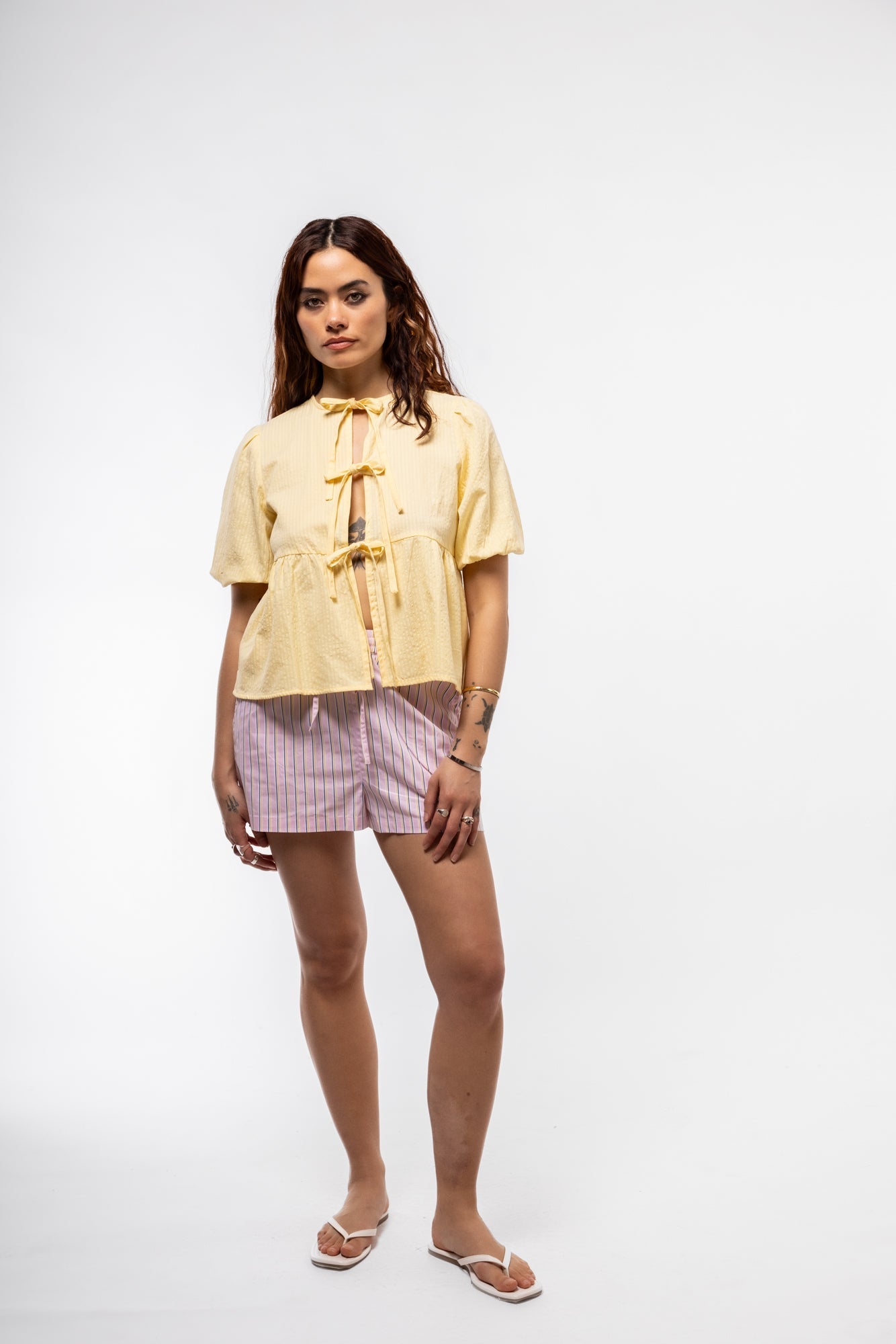 Women’s pastel yellow puff-sleeve cotton top with feminine tie-front