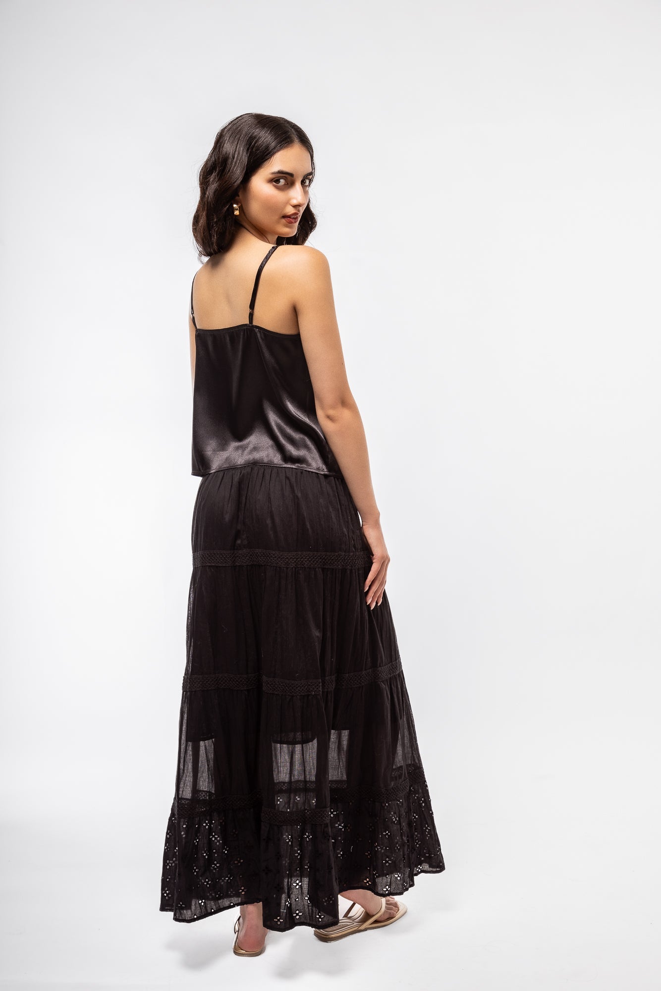 model is wearing the black tiered boho skirt back view