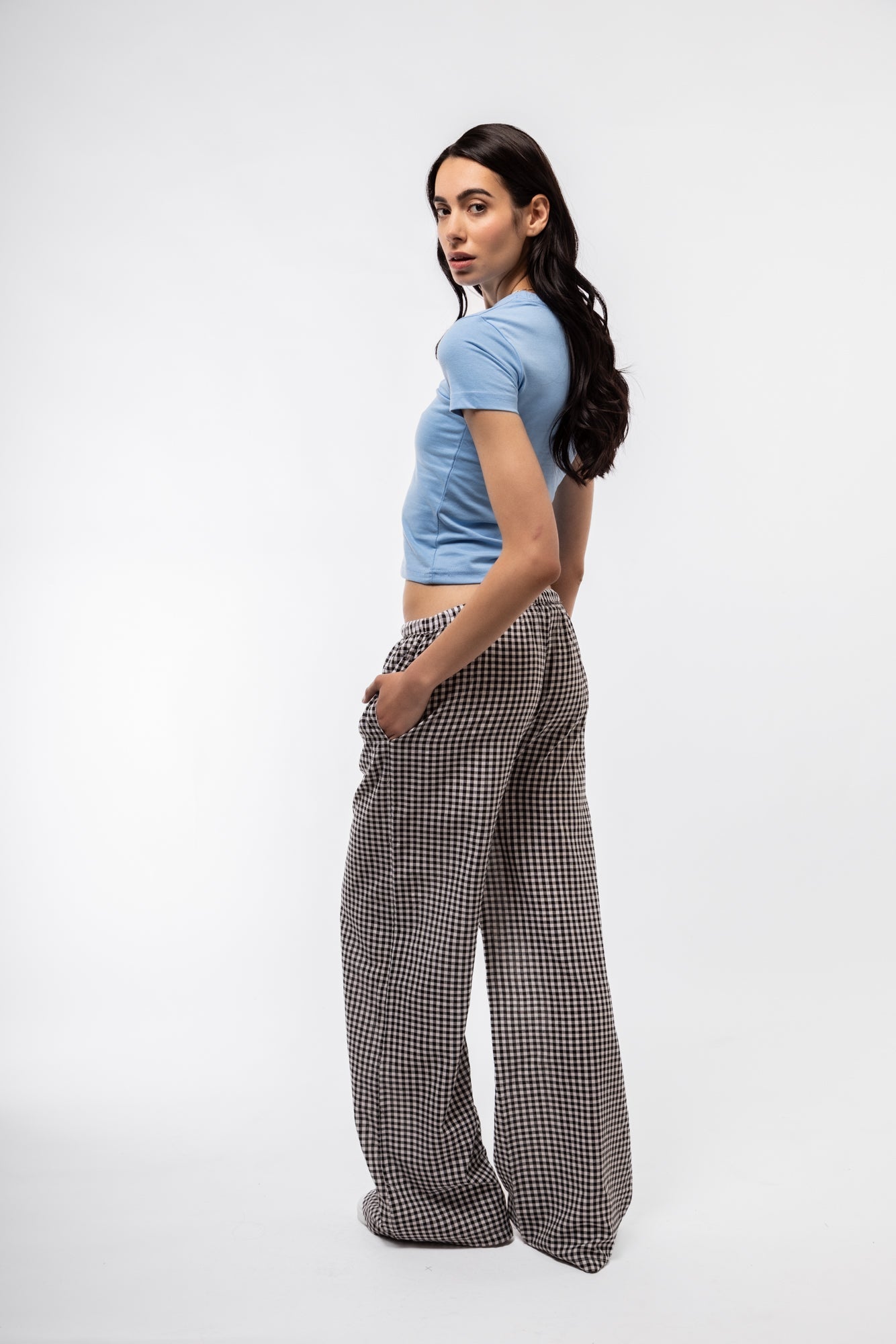 side profile of model wearing the gingham wide leg trousers in black