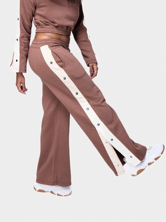 Woman showcasing a raw umber cropped track suit with side snap-button detailing and wide-leg pants.