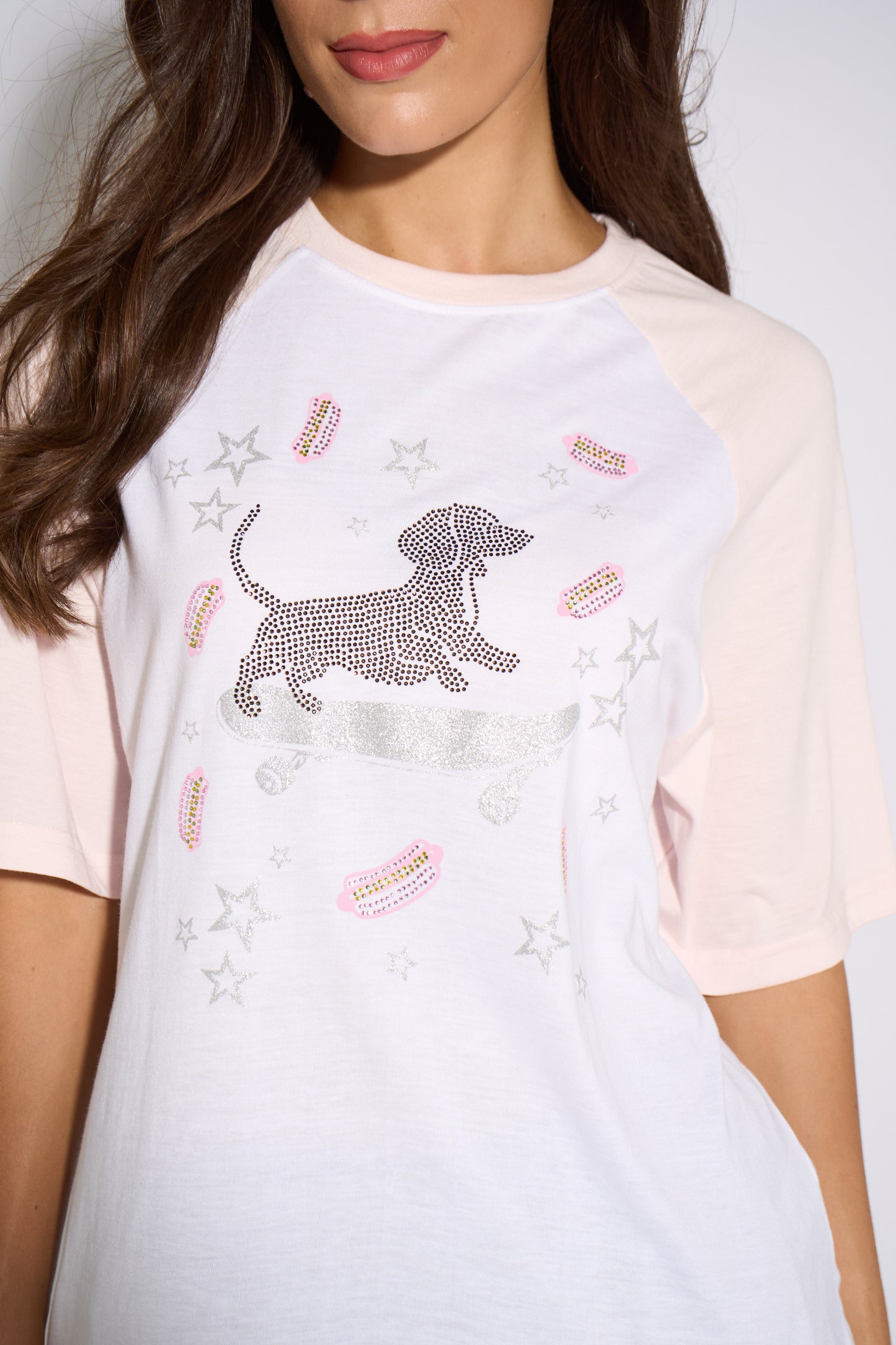 White t-shirt with a dachshund graphic and star embellishments worn by a person.