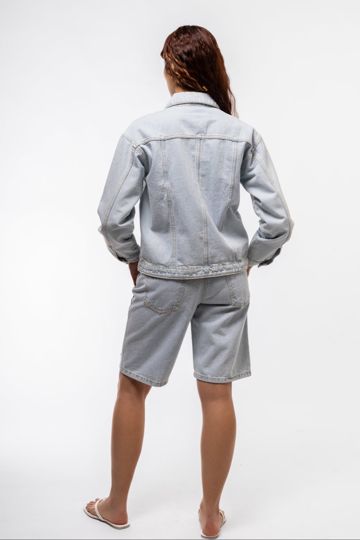 Back image of stud denim jorts highlighting raw edges and stud embellishments on pockets.

