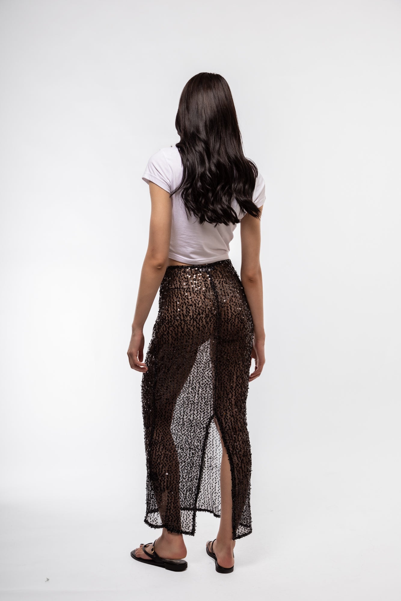 Back profile of glam knit midi skirt with light-catching sequins

