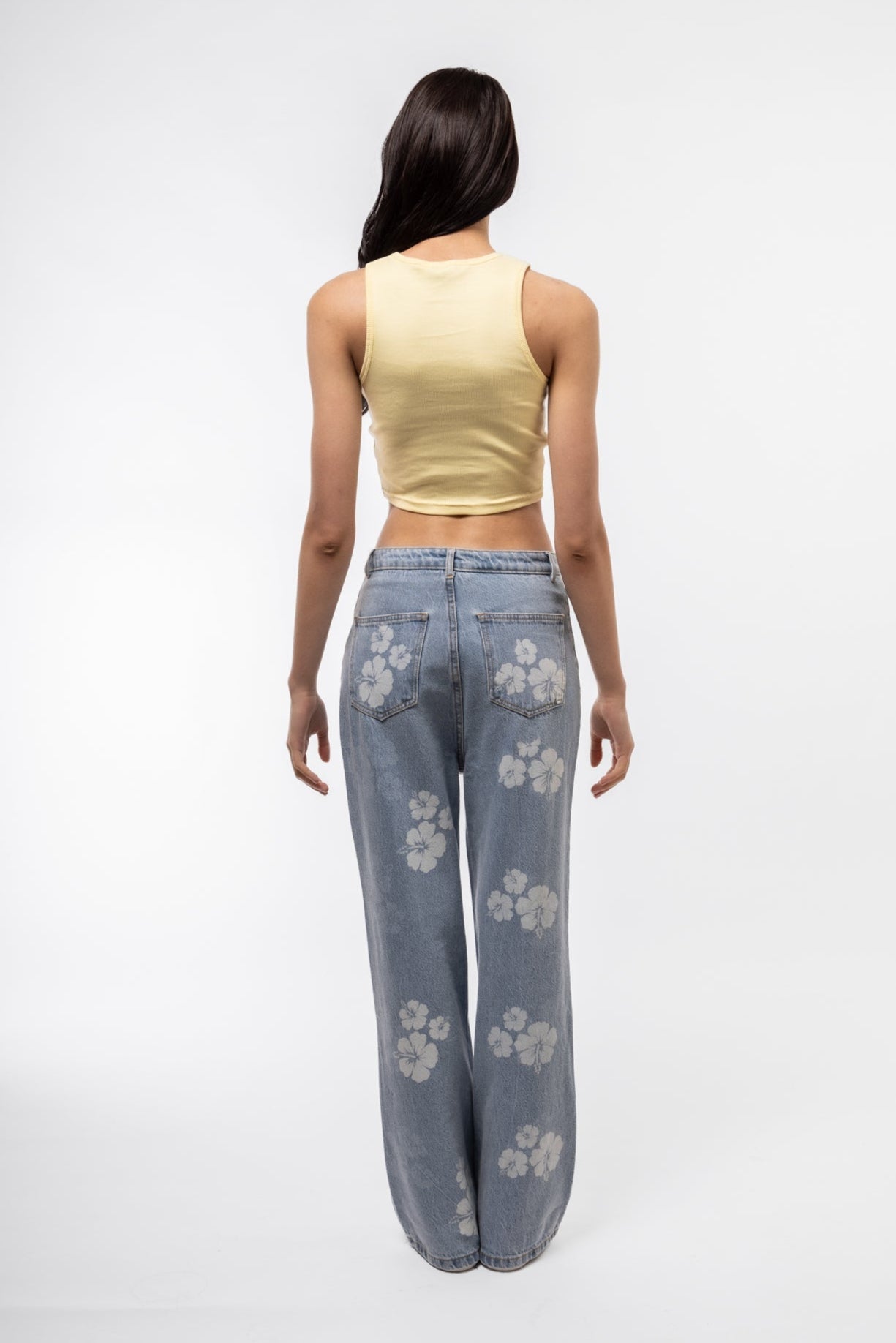Back view of denim printed wide leg jeans showing printed back pockets and wide leg drape.

