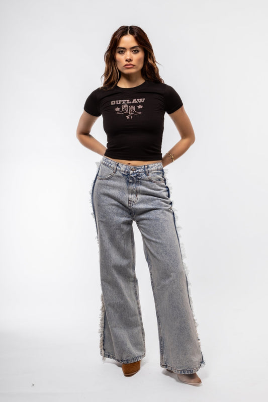 Fringe denim jeans front shot showcasing button fly and faded wash with raw hem fringe

