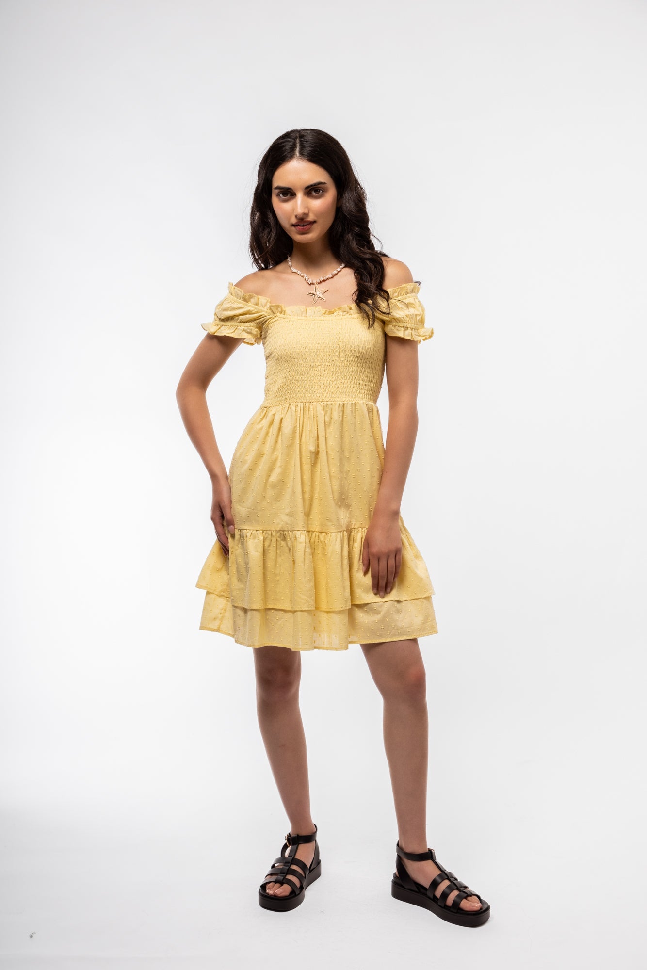 Front-facing image of pastel butter yellow smocked dress with midi-length skirt and soft structure.

