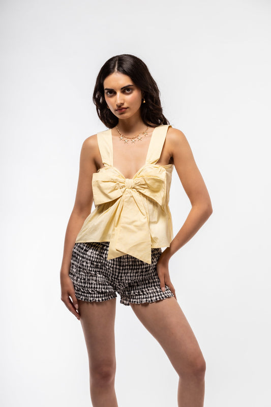 Front view of butter yellow cami top with bow accent and lightweight cotton design.

