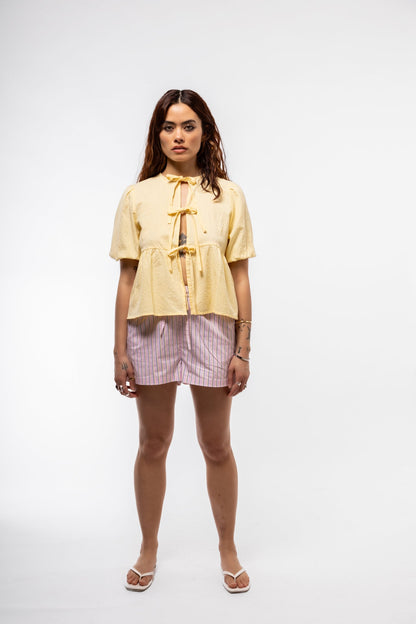 Front view of butter yellow puff-sleeve cotton crop top with tie front
