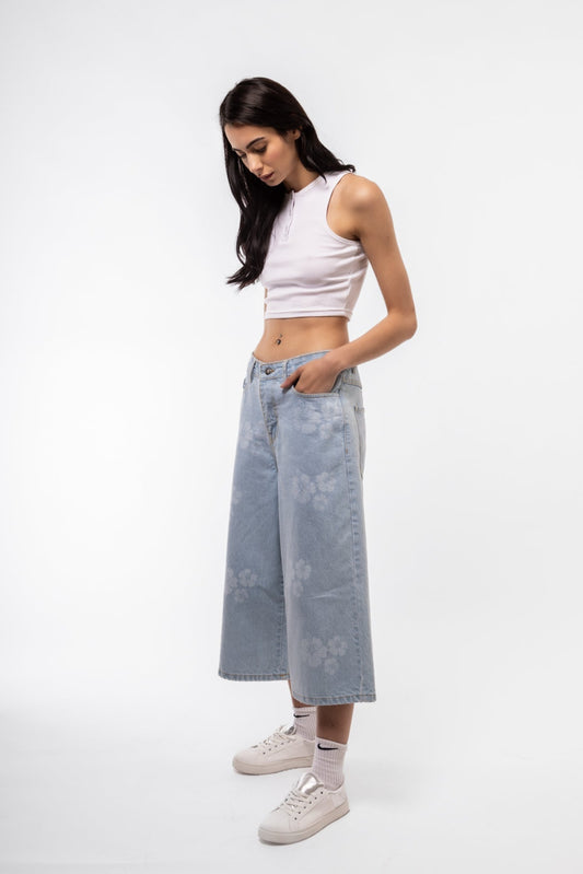 Front view of longline printed denim jorts featuring bold all-over print and raw hem.


