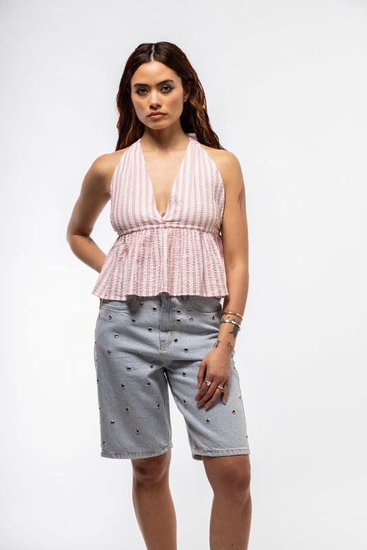 Front view of relaxed casual outfit with sleeveless peplum top and grommet Bermuda shorts