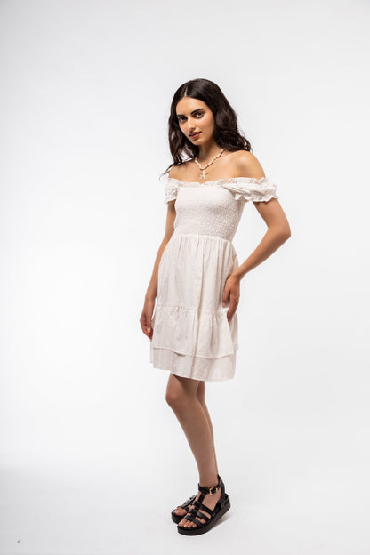 Front view of white shirred tea dress with square neckline, puff sleeves, and flowy midi skirt.

