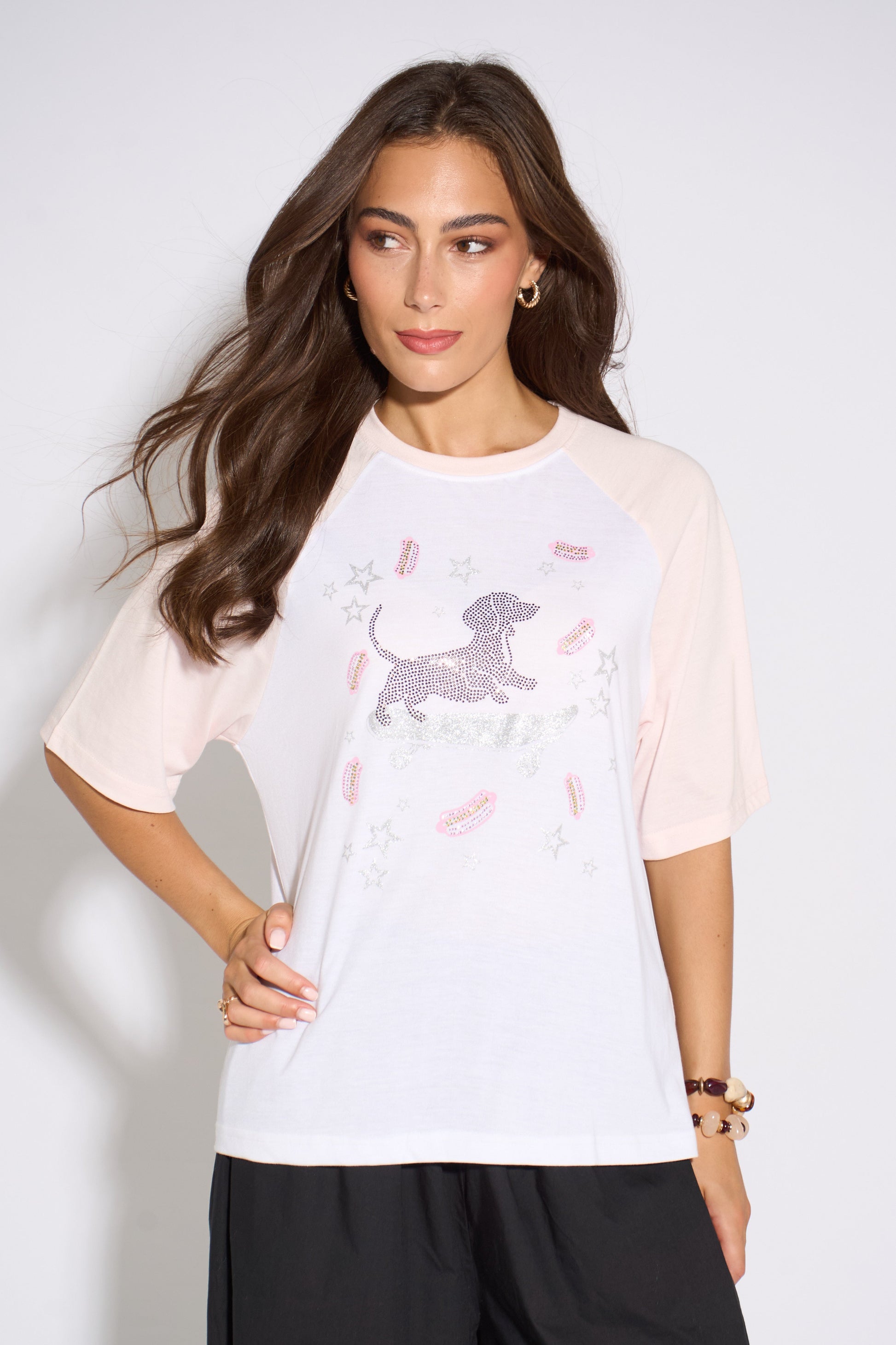 Woman wearing a white t-shirt with a graphic design on a plain background