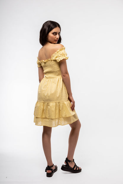 Side-facing shot of summer tea dress in butter yellow with shirred waist and gentle volume.


