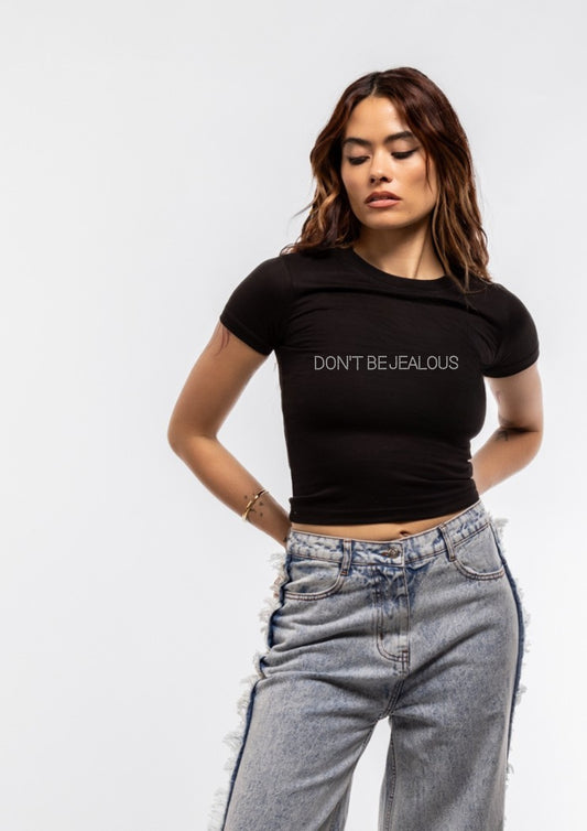 Model wearing a black t-shirt with 'DON'T BE JEALOUS' text on a plain background
