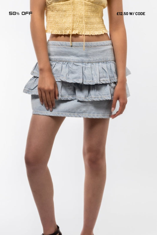 wearing a layered denim skirt on a white background