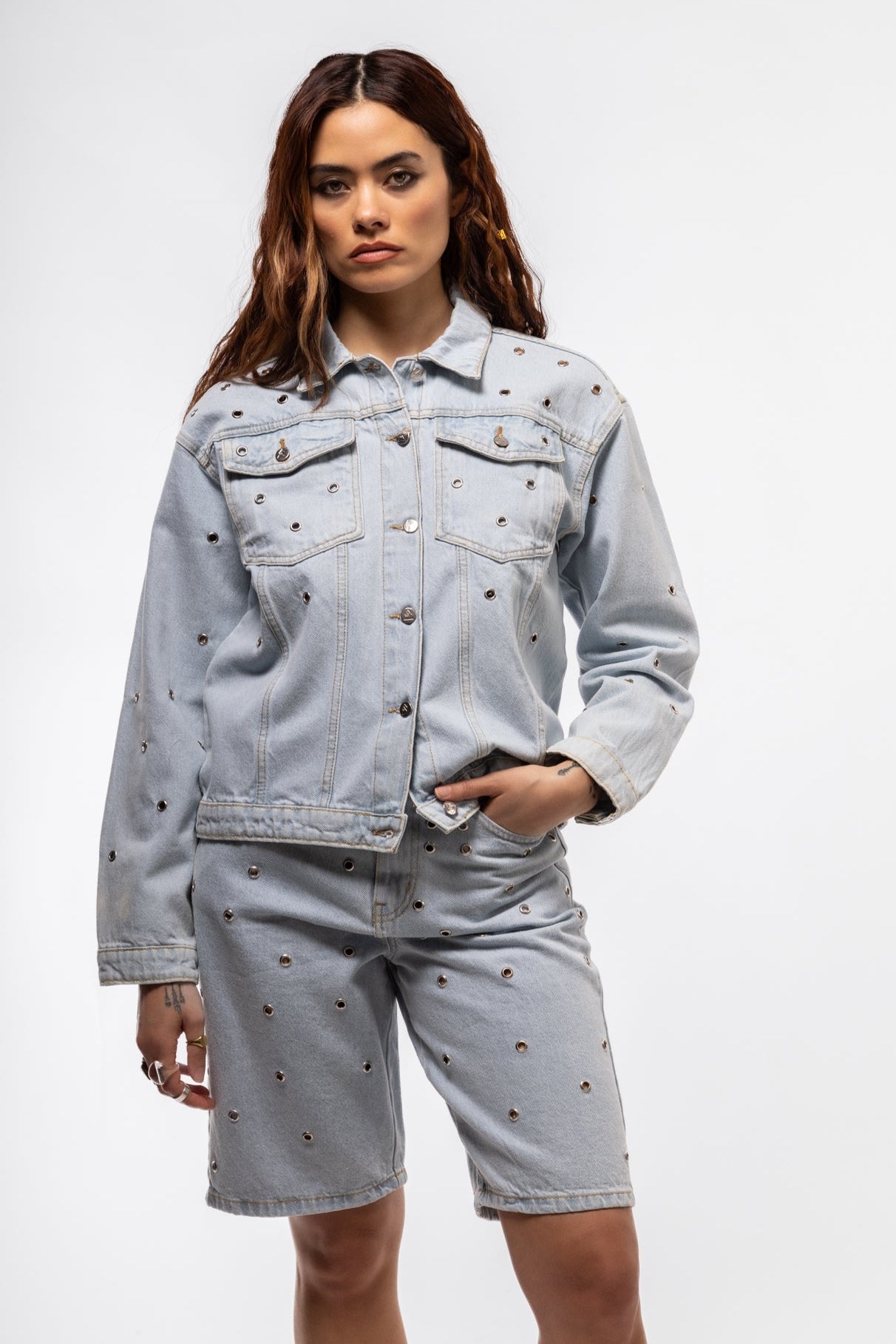Model wearing stud denim jacket styled open for a laid-back, edgy look

