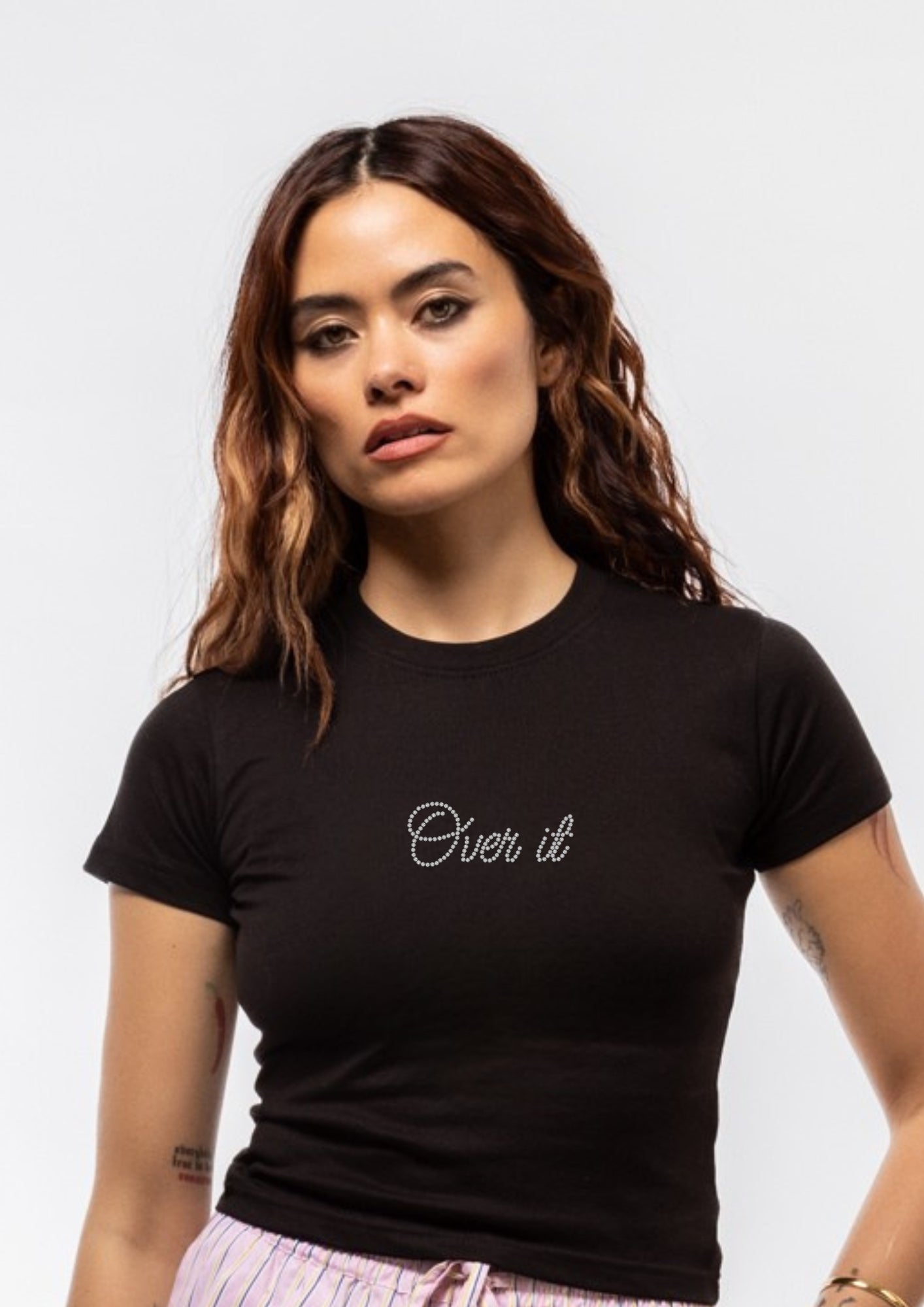 Woman wearing a black t-shirt with 'Over it' text on a plain background