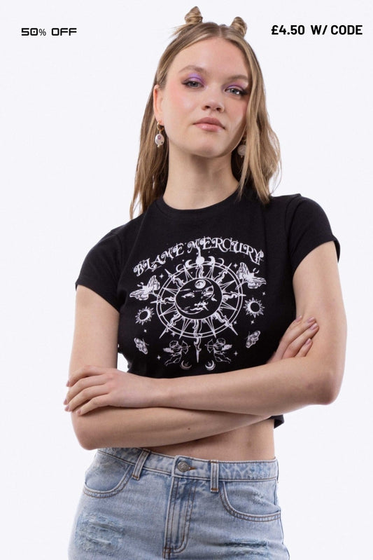 Person wearing a black t-shirt with a white  cosmic graphic design on a plain background