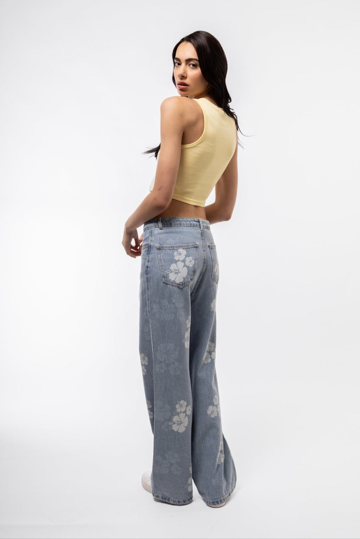 Printed denim wide leg pants side angle highlighting flared leg and bold pattern.

