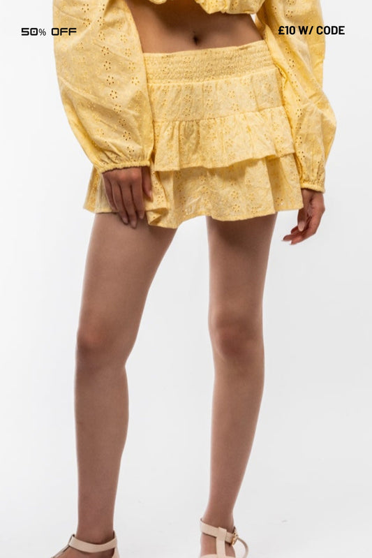 Person wearing a yellow outfit with a skirt on a white background