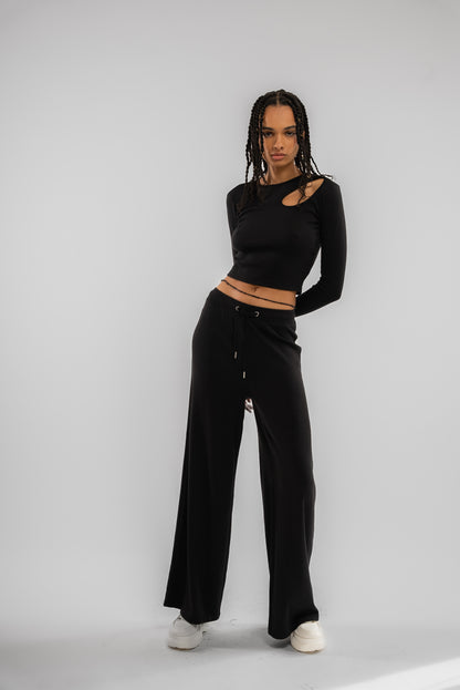 a woman wearing a black basic rib wide leg trousers 