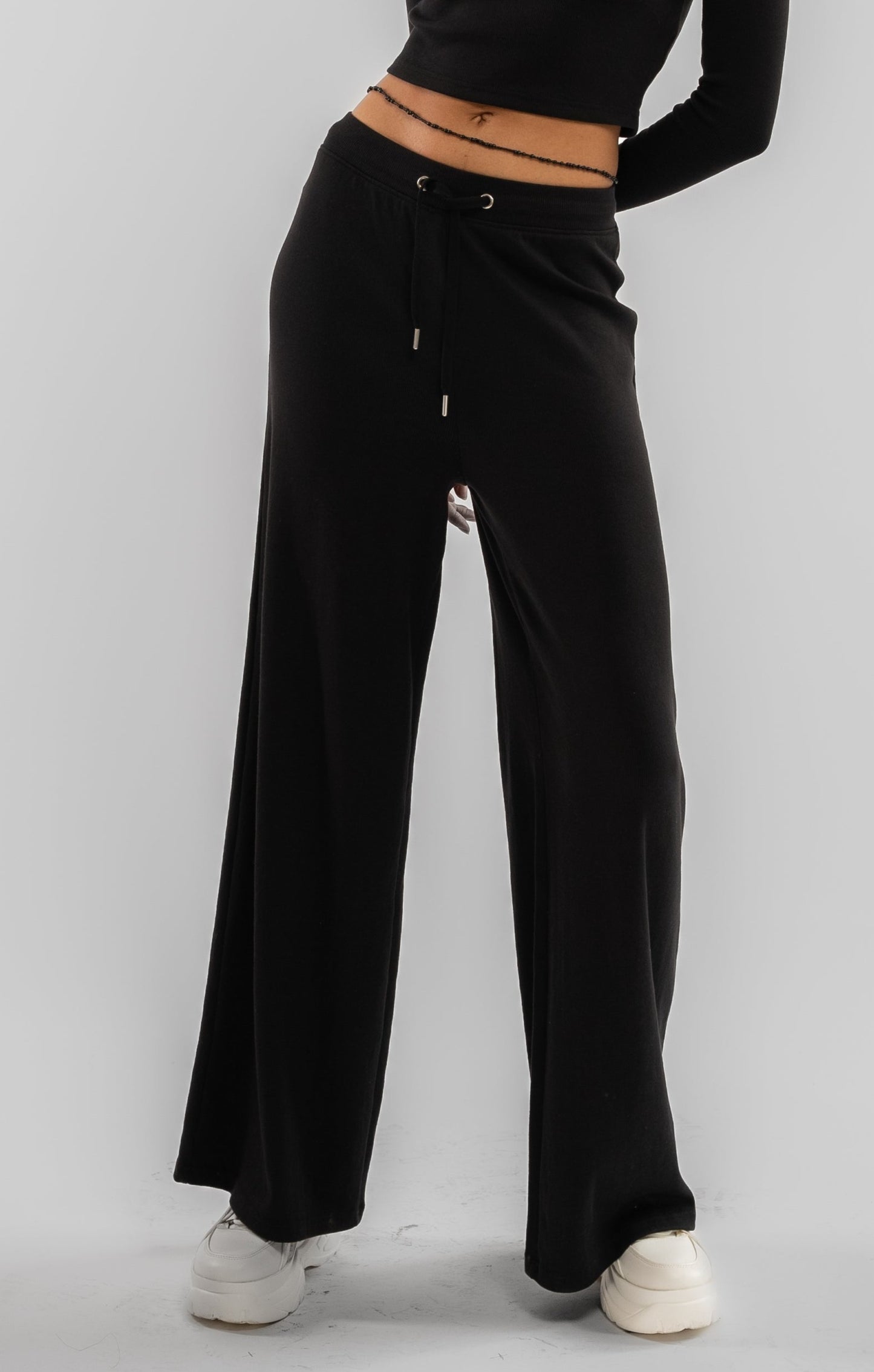 a woman wearing a black basic rib wide leg trousers 