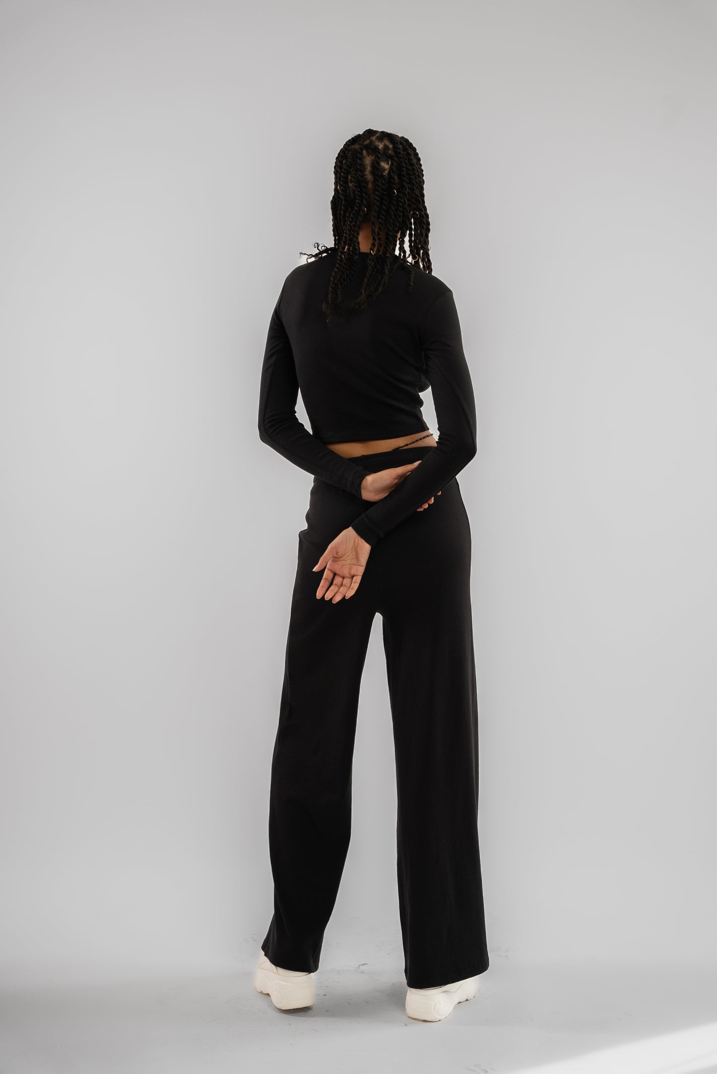 a woman in a black cut out long sleeve rib crop top posing for a picture