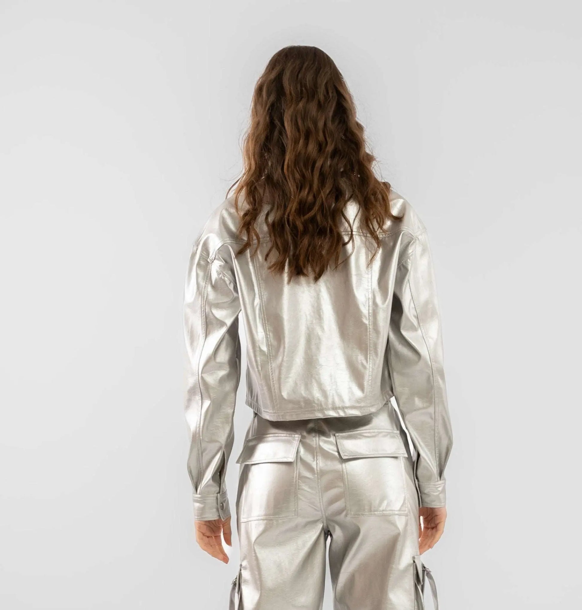 a woman showing the silver coated faux leather trucker jacket 