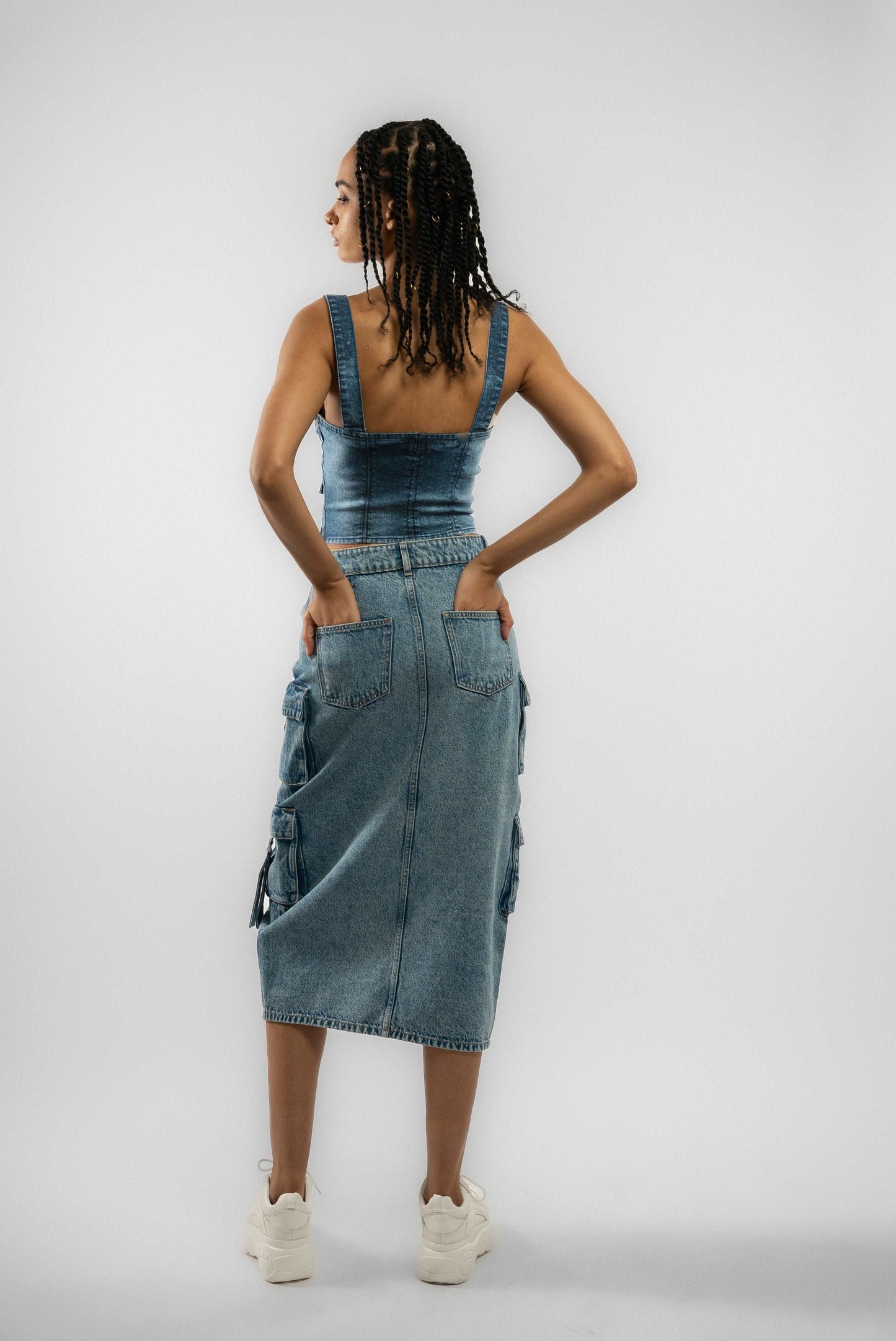 a woman in a denim dress with her hands on her hips