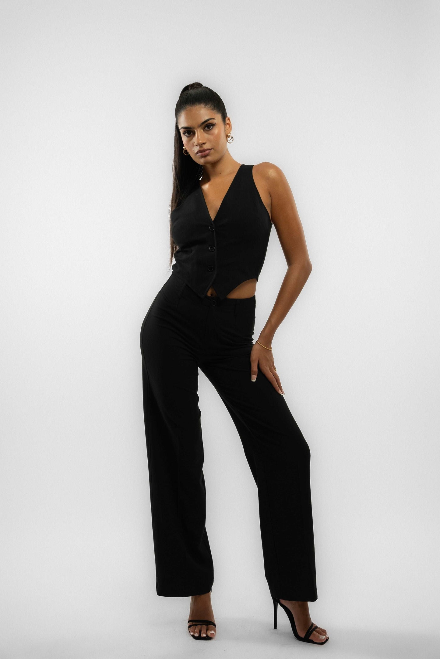 a woman in a black tailored wide leg trouser posing  