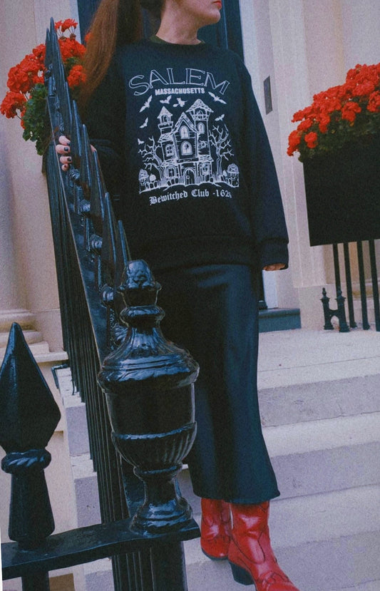 Person wearing a black season halloween sweatshirt salem 