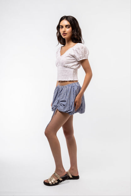 Side Profile View of the blue gingham skirt with tie detail on the skirt 