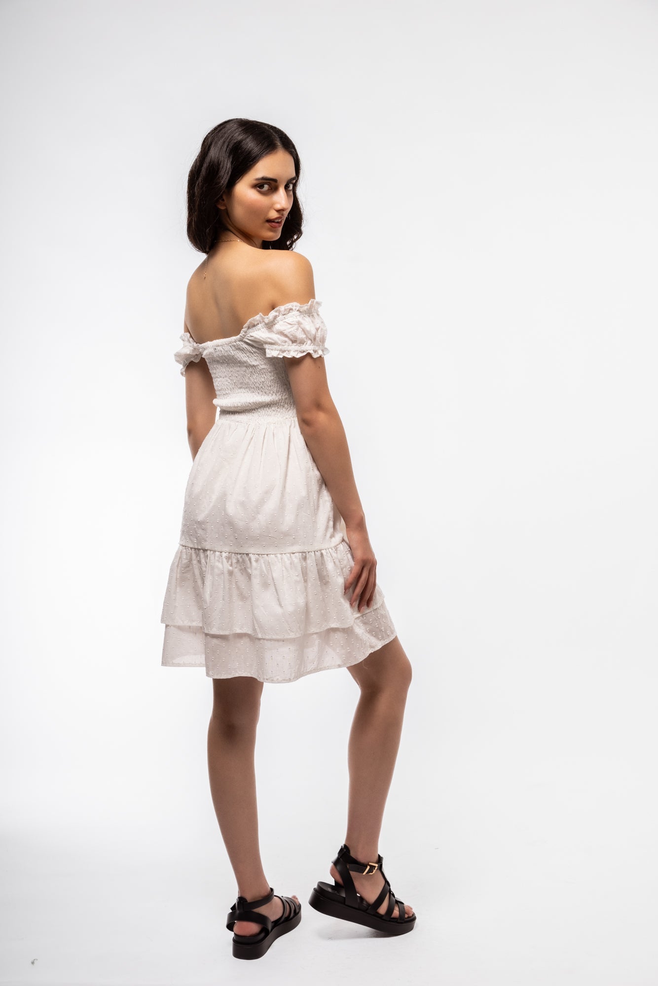 Side profile of white cotton tea dress with shirred bodice and fluttery short sleeves.

