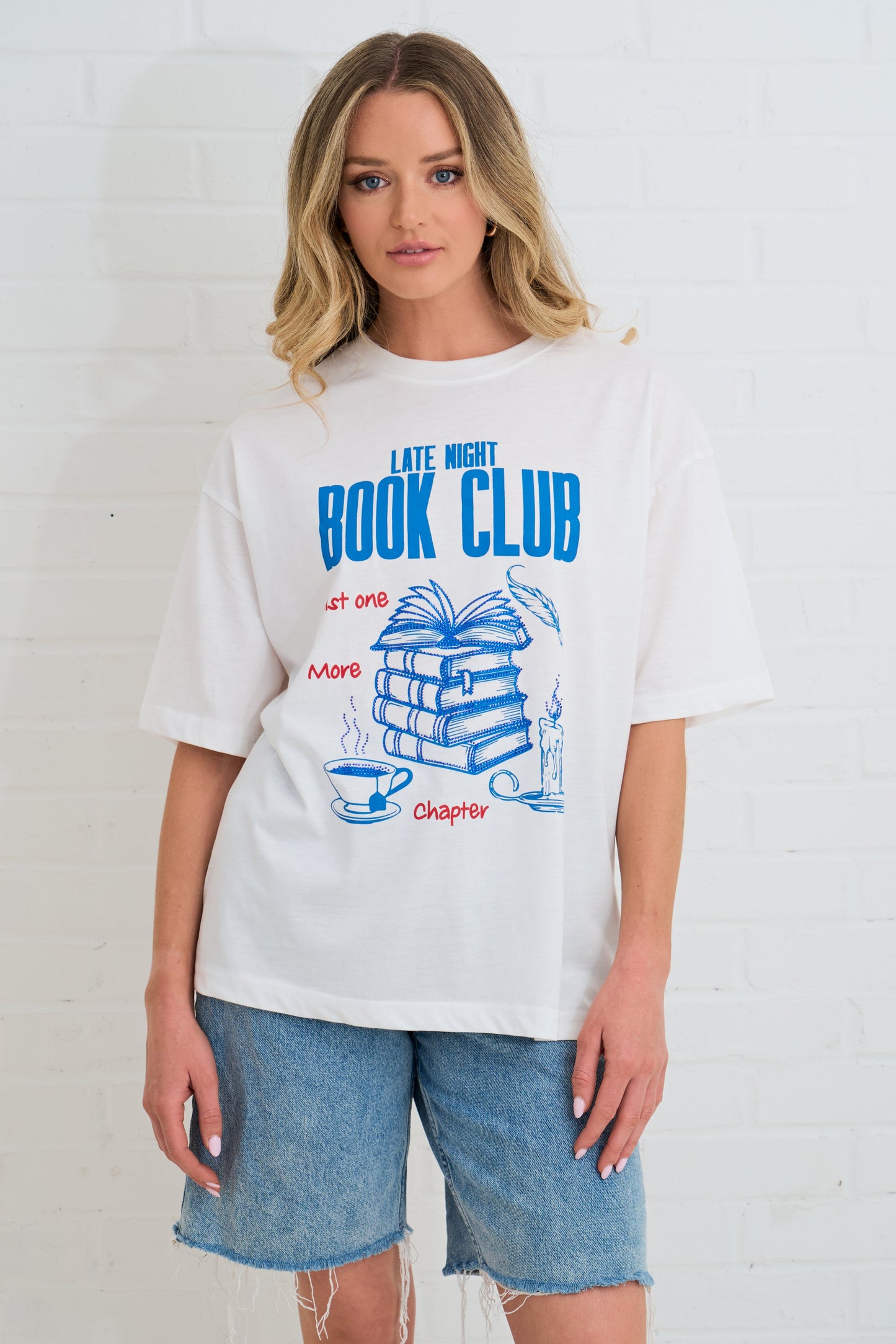 Person wearing a white t-shirt with 'Late Night Book Club' design on a plain background