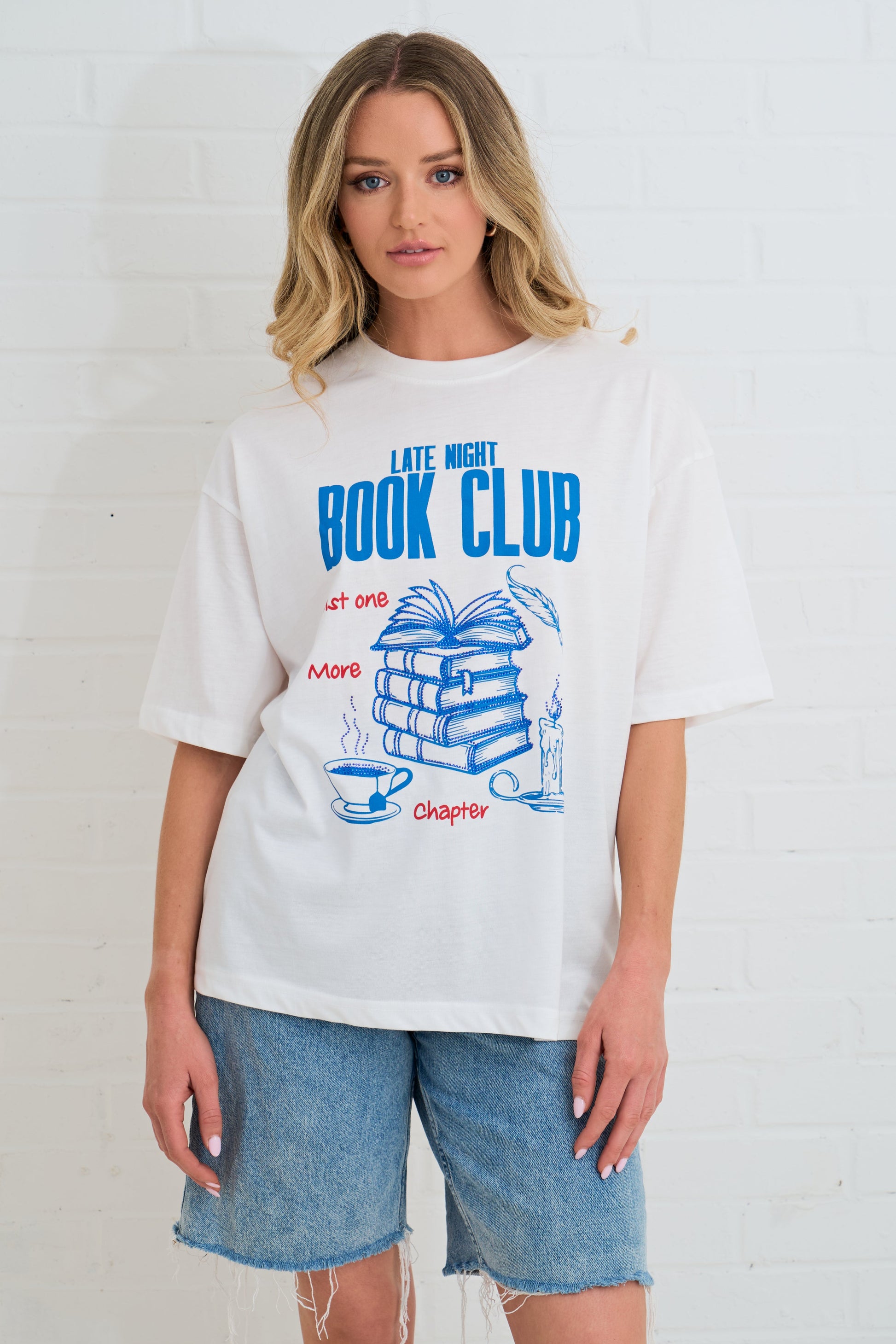 Person wearing a white t-shirt with 'Late Night Book Club' design on a plain background