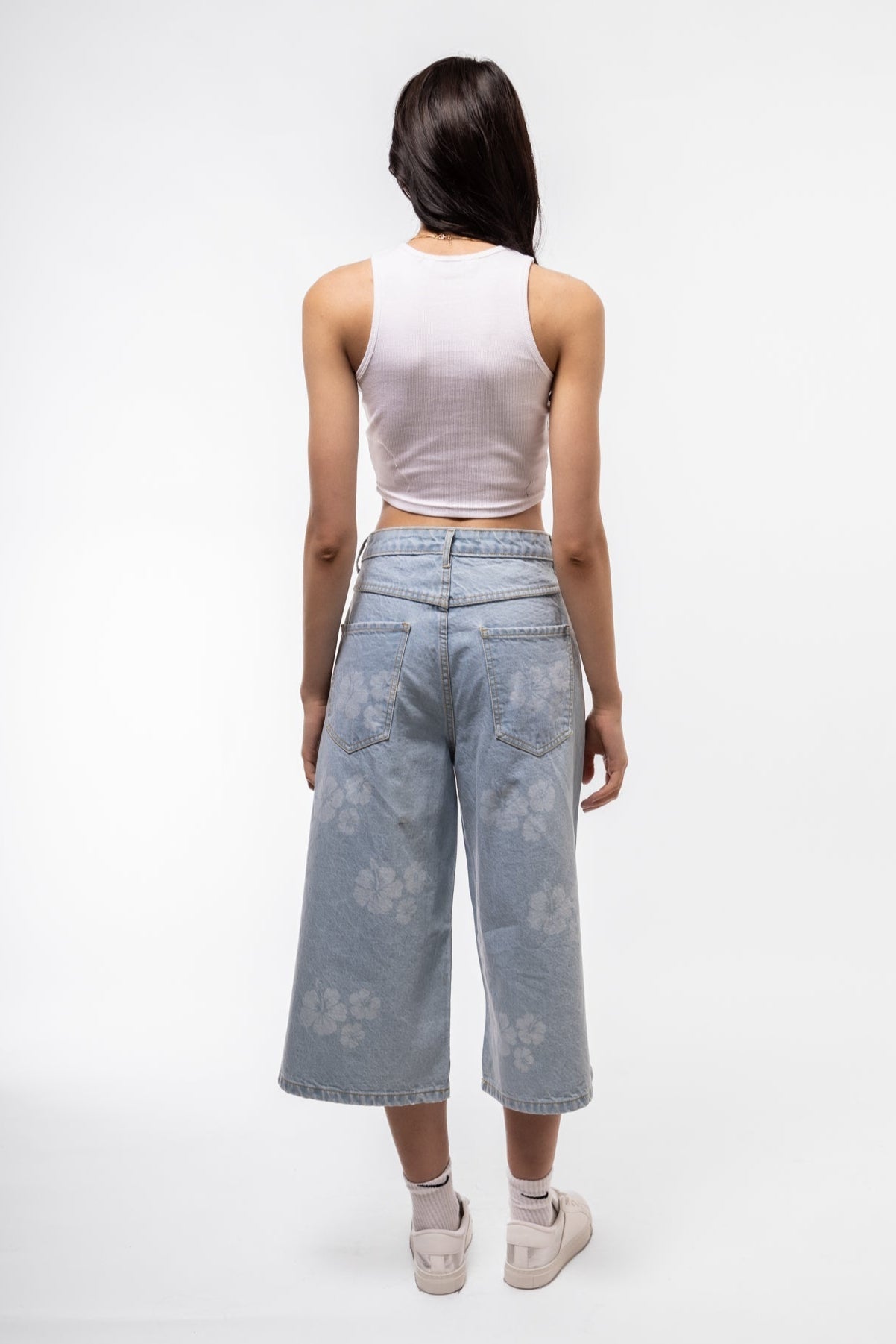 Street-style printed longline denim jorts rear image with bold graphic detailing and drop length.

