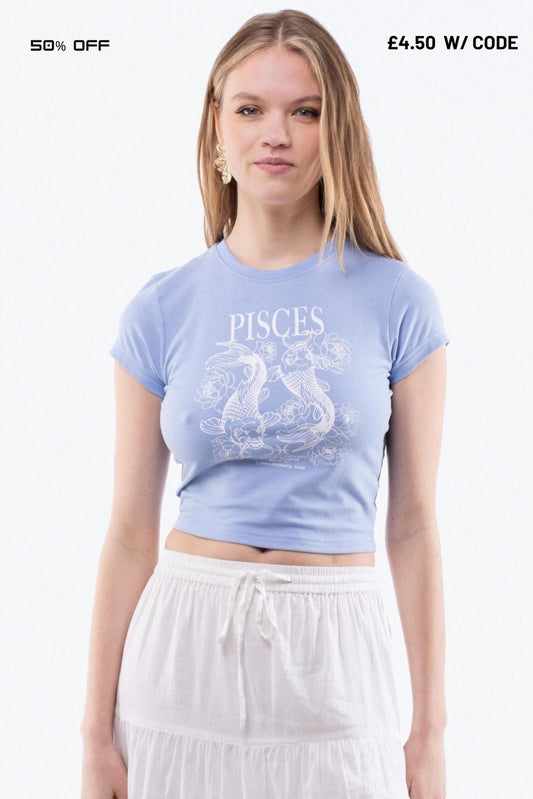 Woman wearing a light blue 'Pisces' t-shirt with a white graphic on a white background